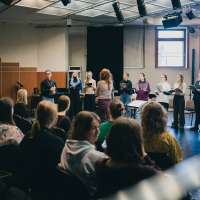 zdjęcie z warsztatów dla zespołów wokalnych przedstawiające ich uczestników